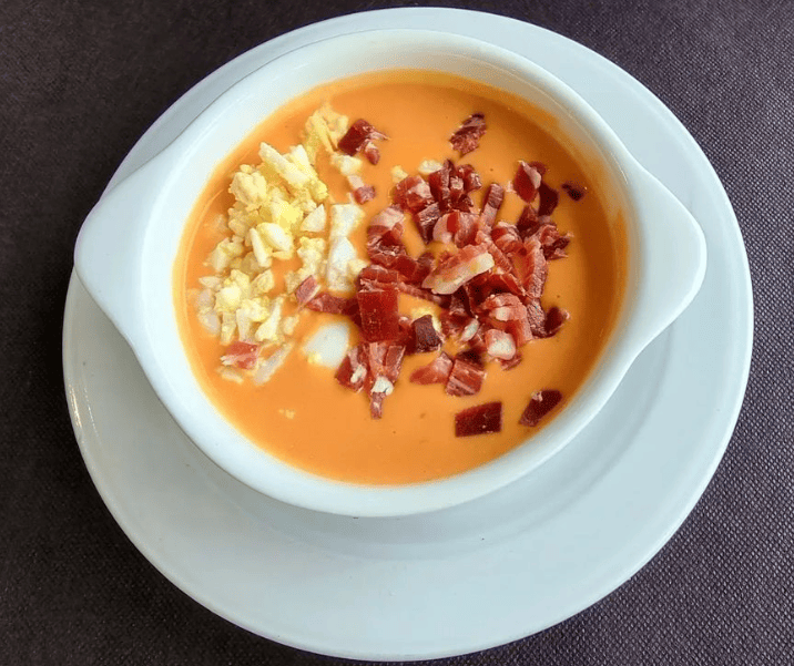 Plato con salmorejo adornado con huevo y jamon